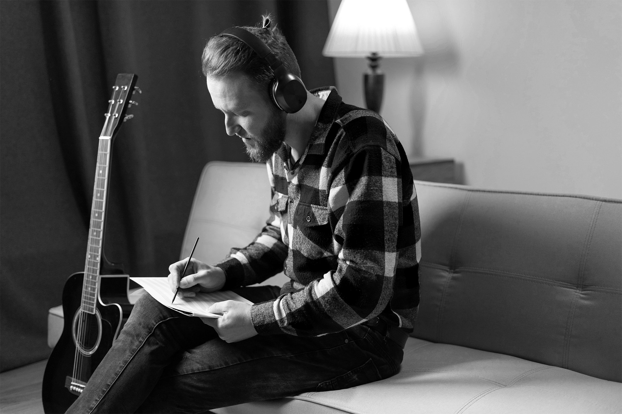 man with guitar writing music